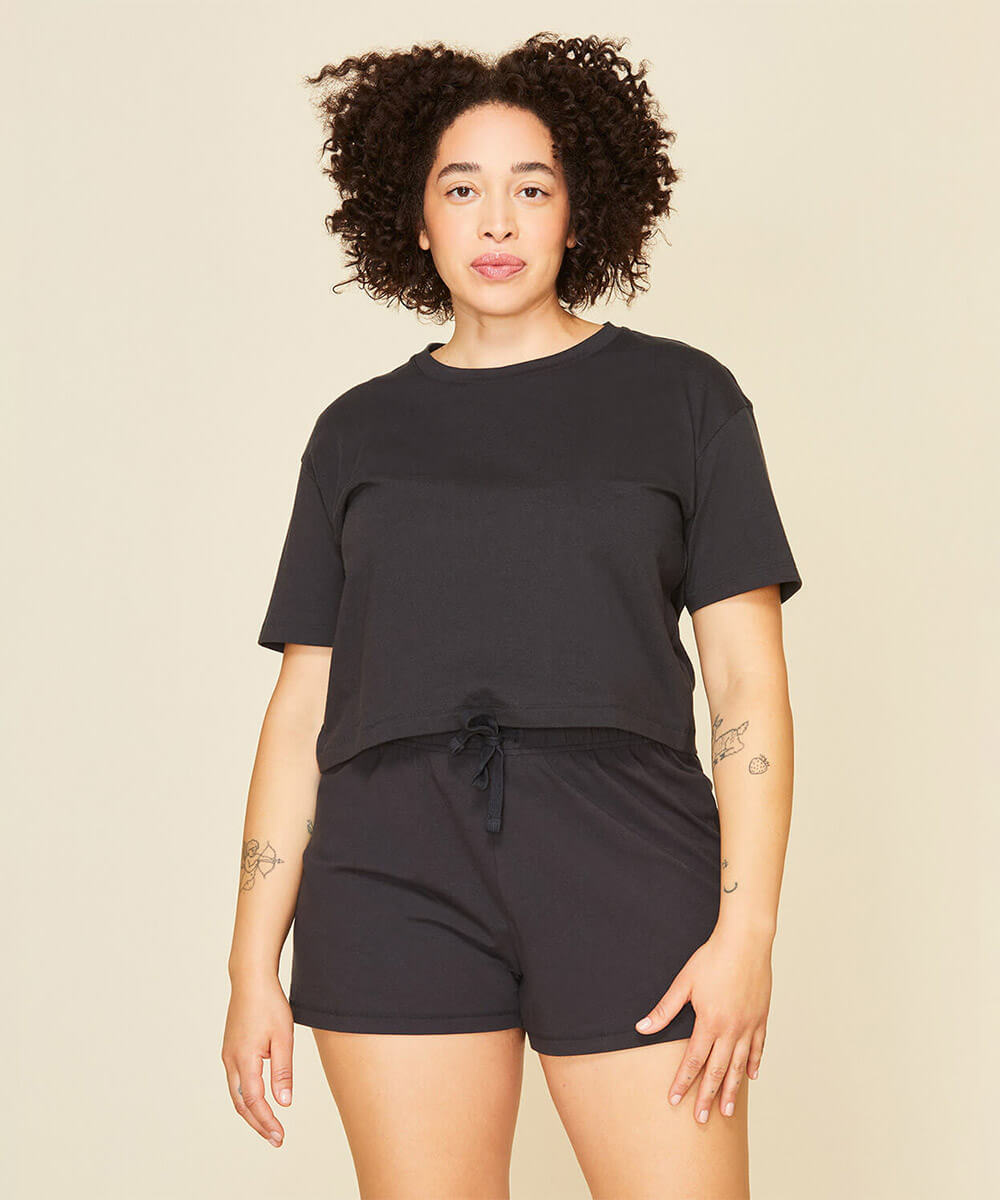 Woman wearing the boxy tee in graphite gray and the soft short in graphite gray color.