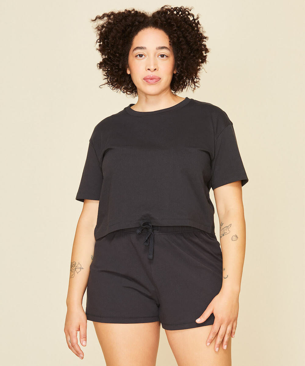 Woman wearing the boxy tee and soft shorts in graphite gray color.