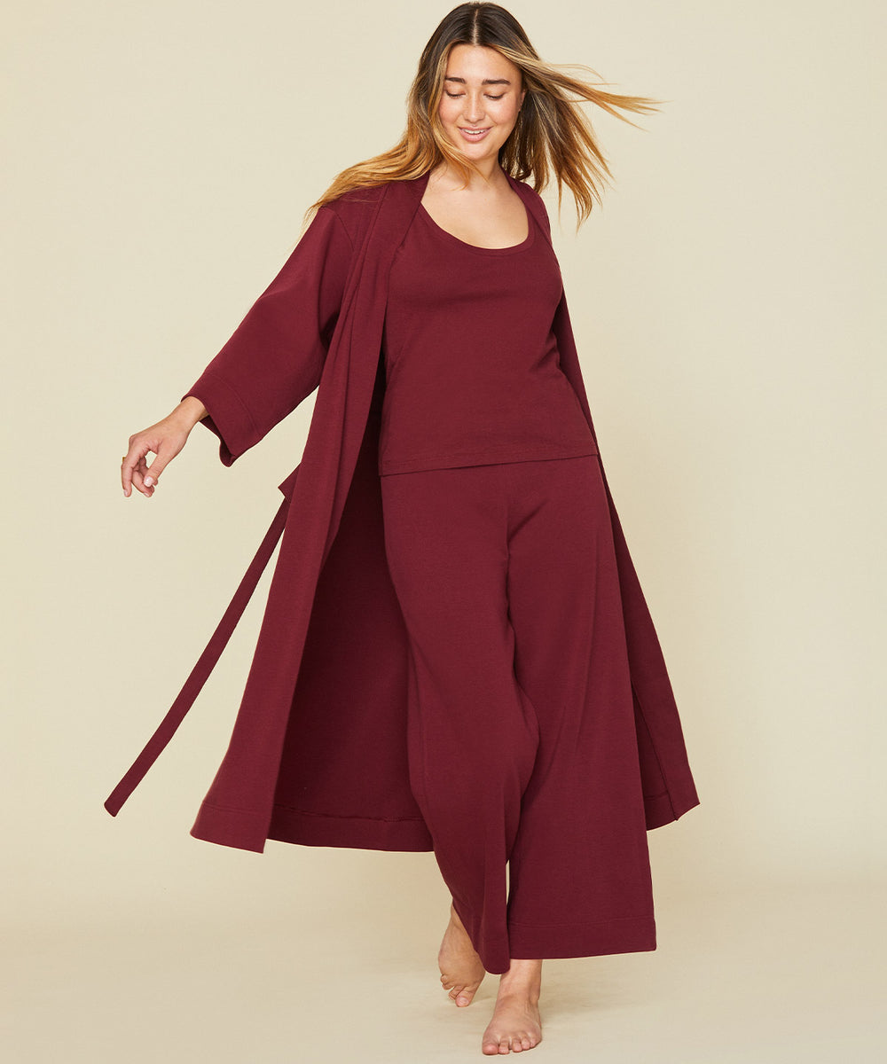 Woman wearing the essential robe in garnet red color.
