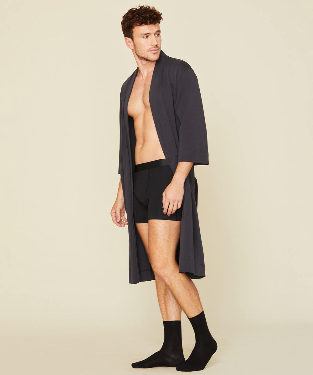 Man wearing the essential robe in graphite gray and the men's boxer brief in carbon black color.