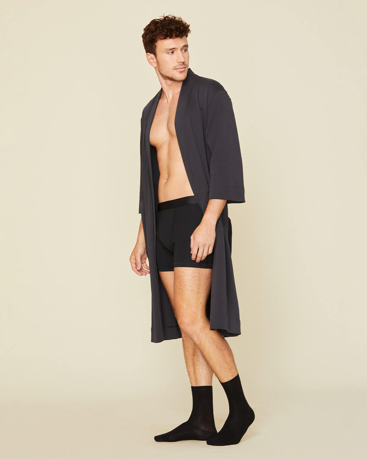 Man wearing the essential robe in graphite gray and the men's boxer brief in carbon black color.