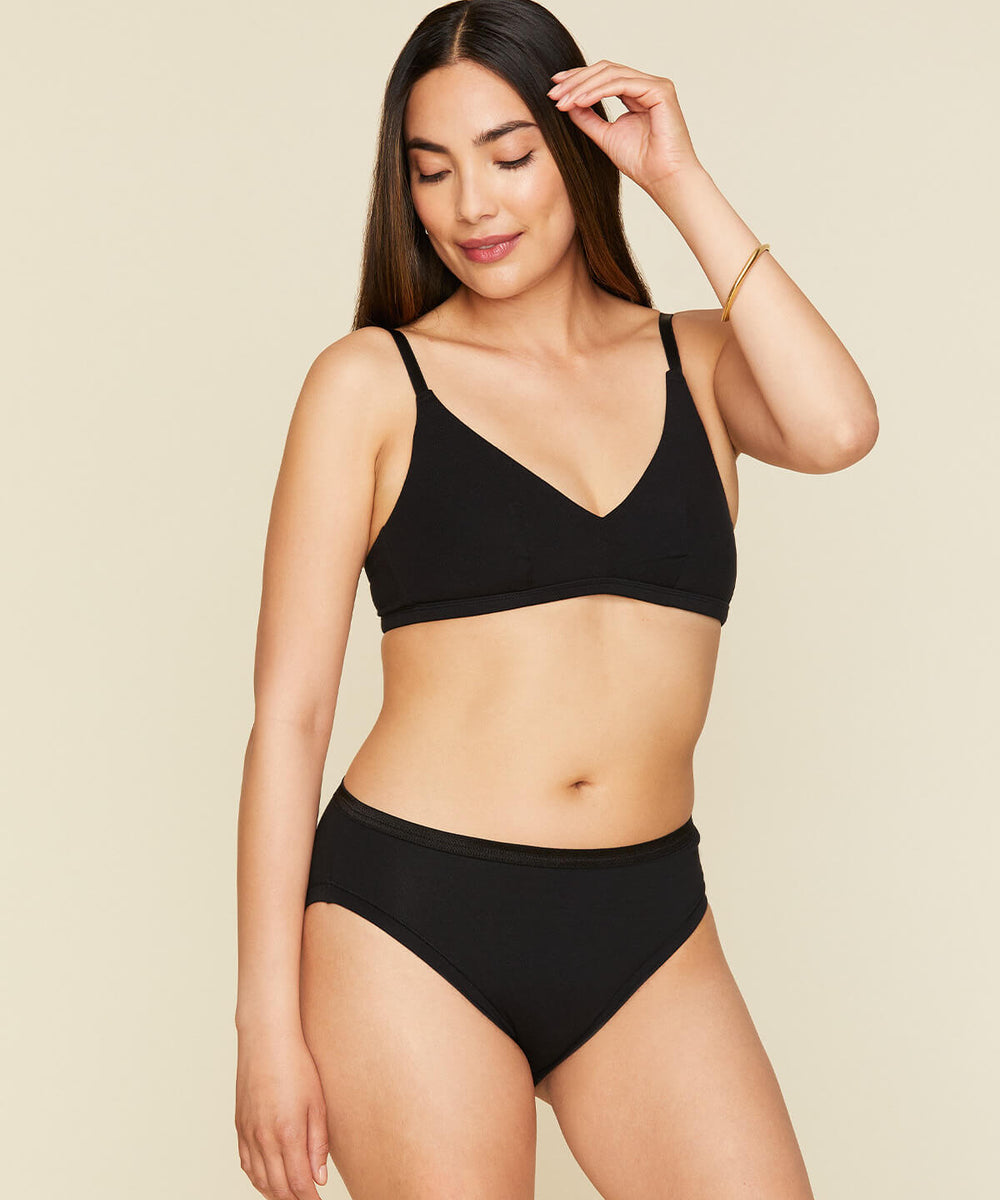 Woman wearing the mid rise bikini in carbon black color. 