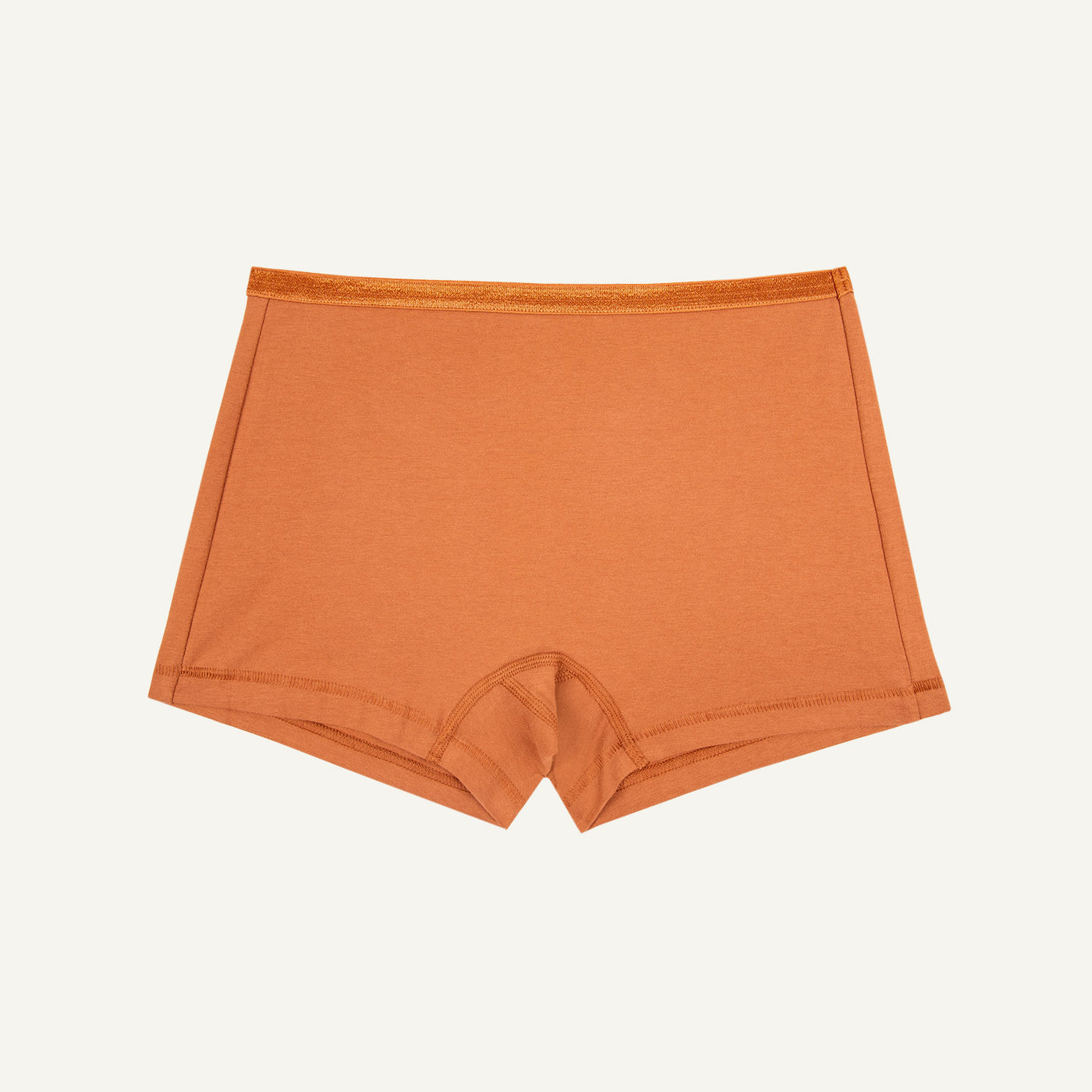 A mid-rise, boy-short style organic cotton underwear in a spice orange color.