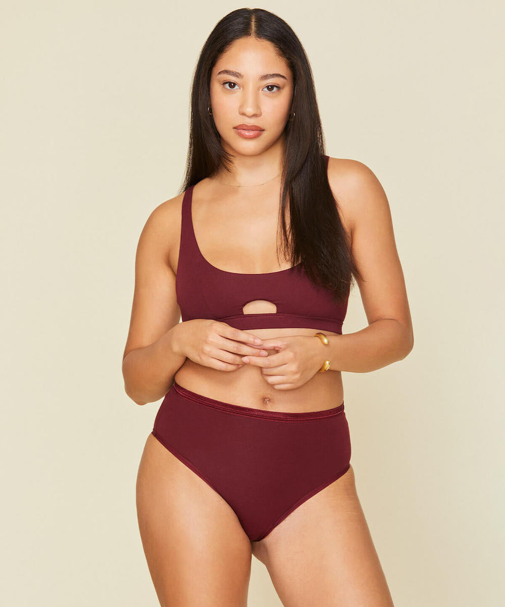 Woman wearing the keyhole bra in garnet red color.