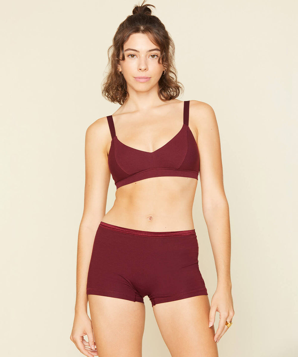 Woman wearing the triangle bra in garnet red and mid rise shortie in garnet red color.
