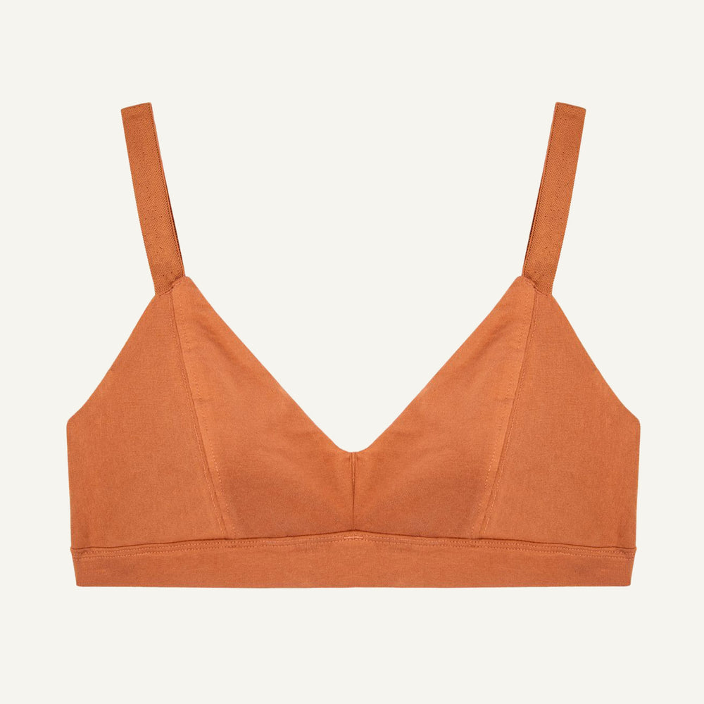An organic cotton triangle soft bra in spice orange color with adjustable straps and a center seam.