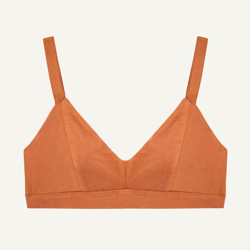 An organic cotton triangle soft bra in spice orange color with adjustable straps and a center seam.