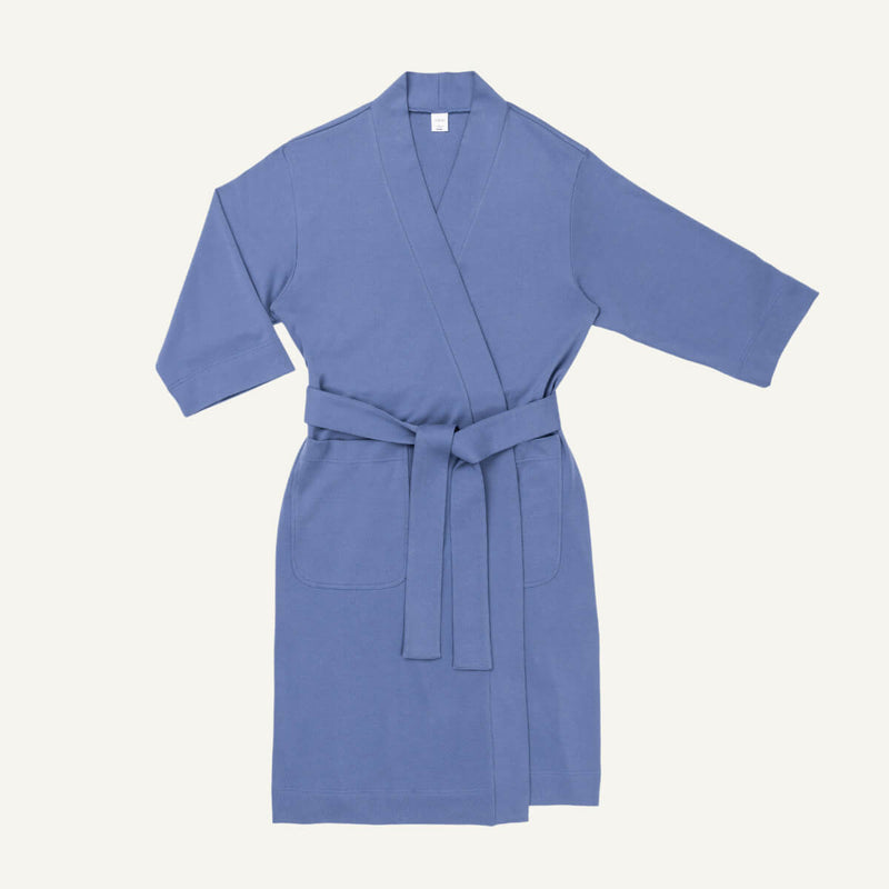 A gale blue organic cotton essential robe with 3/4 sleeves and a half-calf length, featuring large front patch pockets and a belted waist.