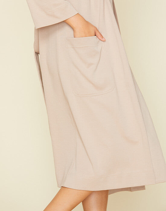 Woman wearing the essential robe in stone beige color.