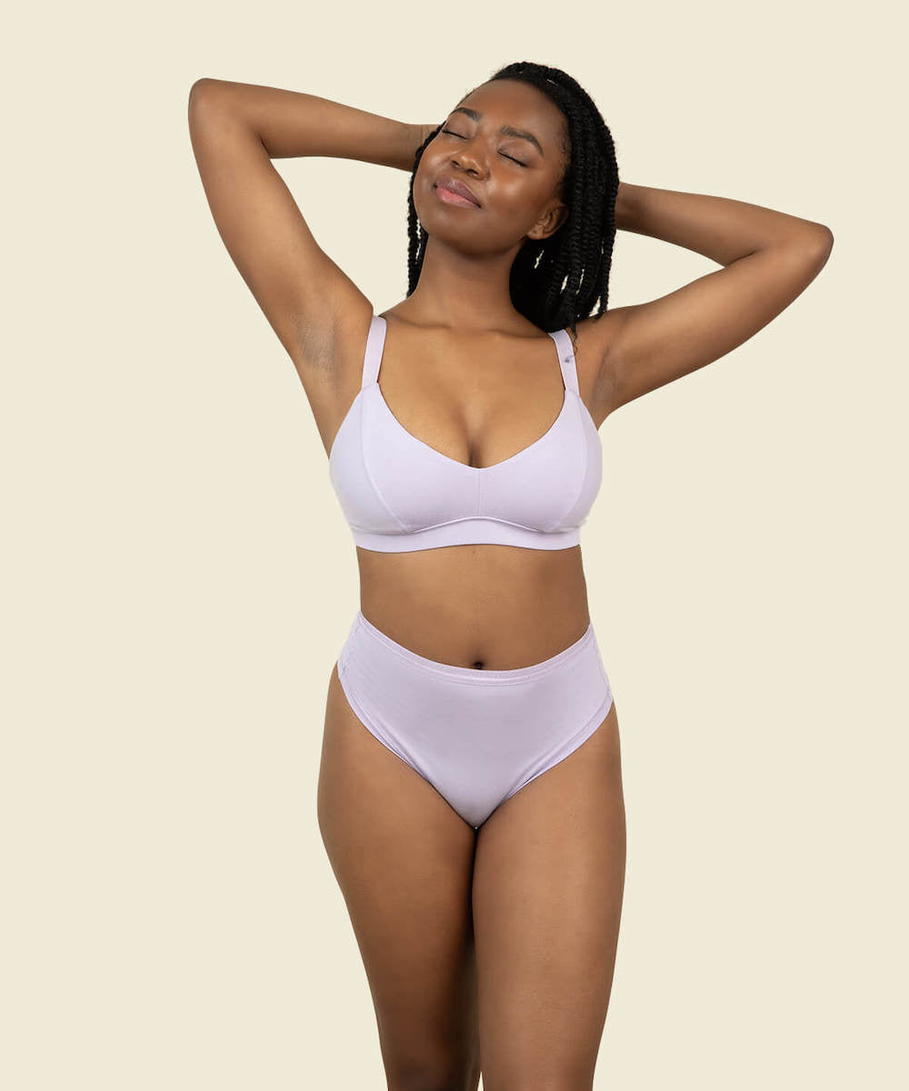 Woman wearing the high rise thong in petal and soft bra in petal purple color.