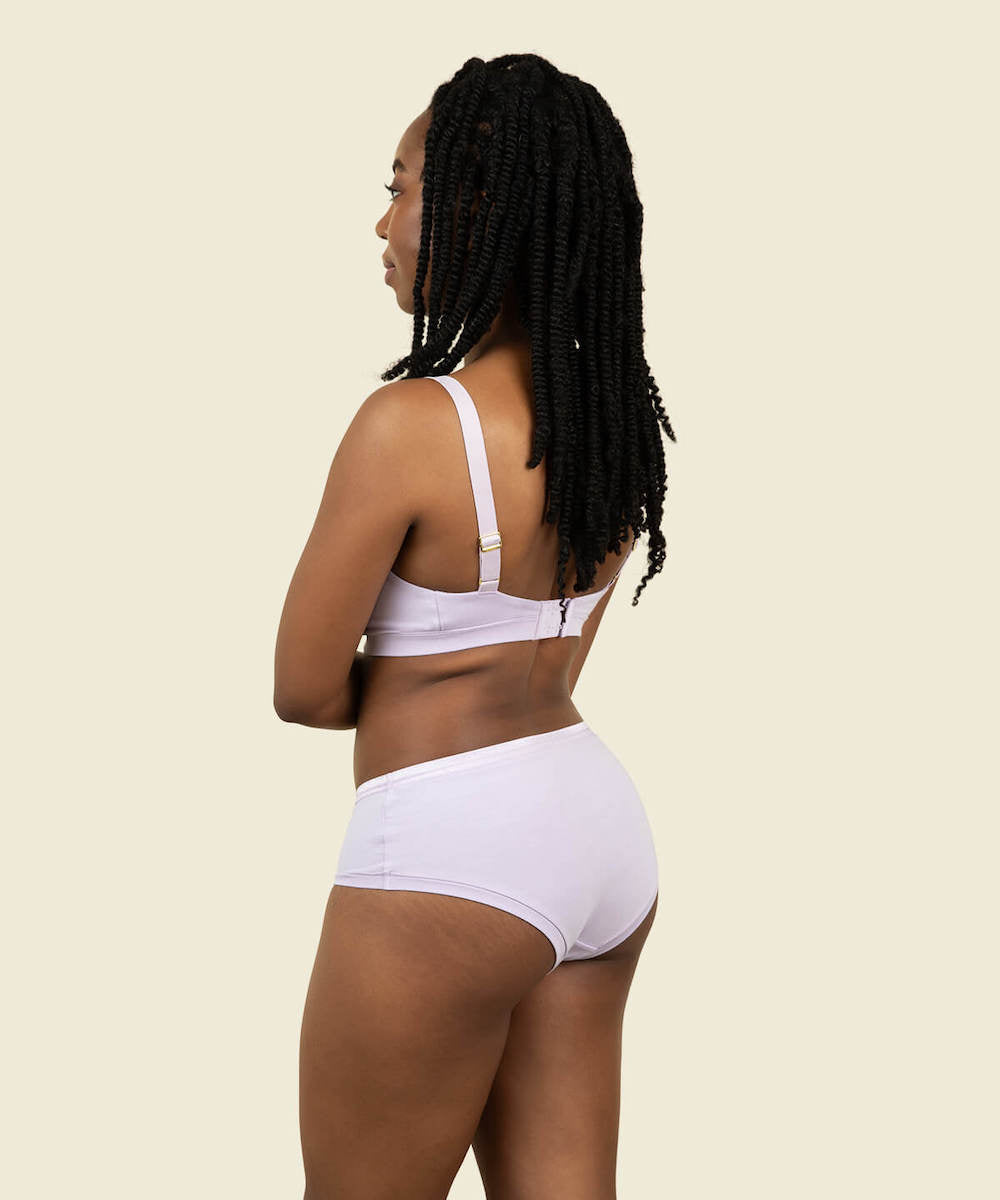 Woman wearing the mid rise hipster in petal and the triangle soft bra in petal purple color.
