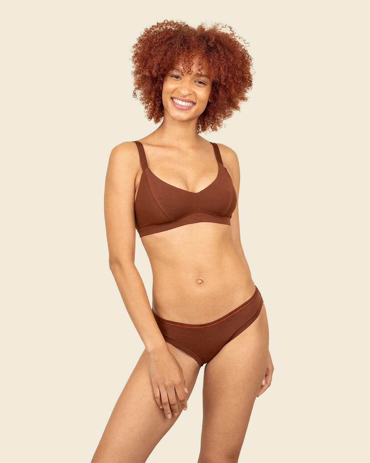 Woman wearing organic cotton low-rise bikini and triangle soft bra in cacao brown color.