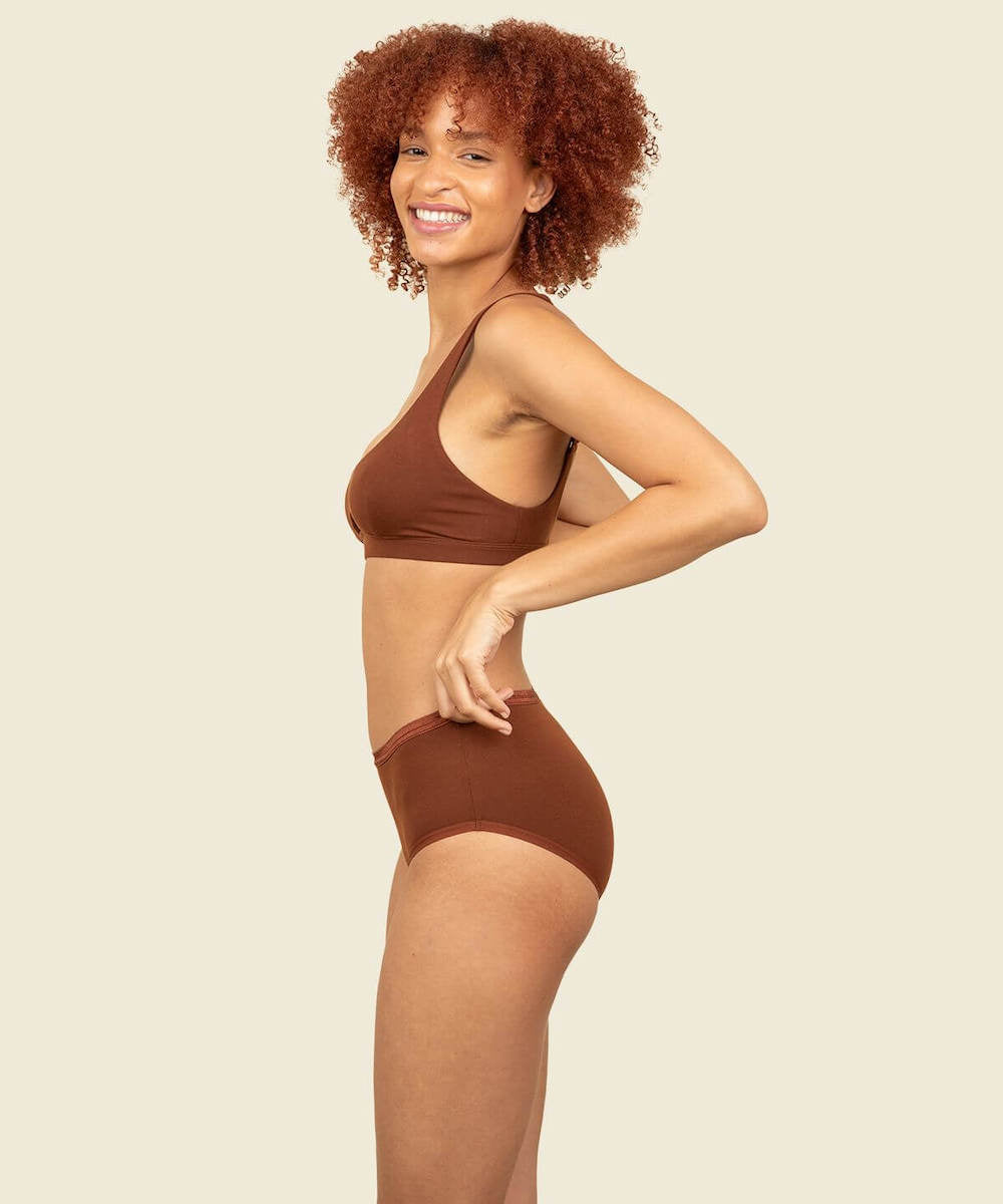 Woman wearing organic cotton mid-rise brief and keyhole soft bra in cacao brown color.