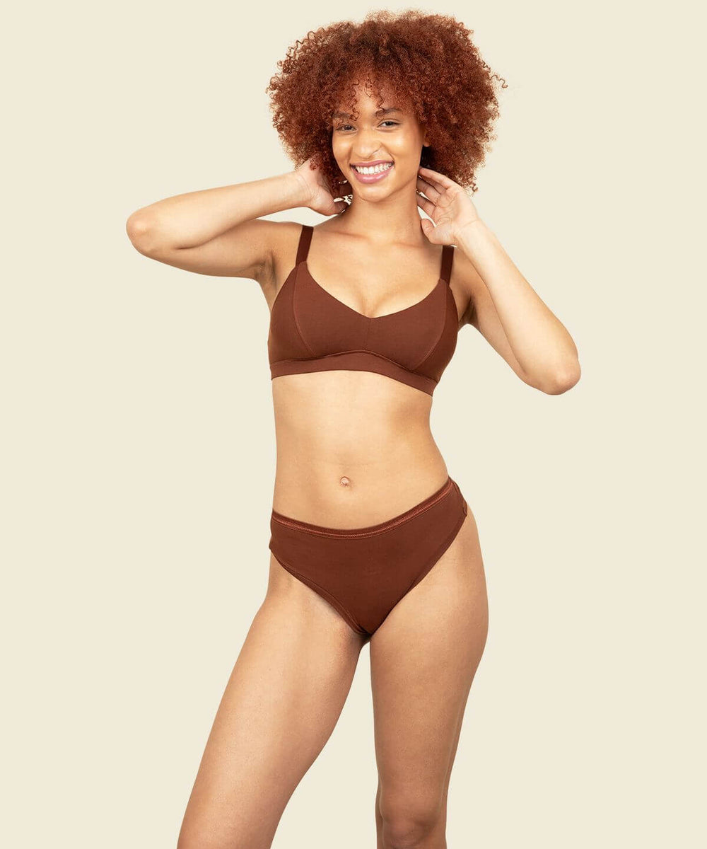 Woman in organic cotton mid-rise thong and triangle soft bra in cacao brown color.