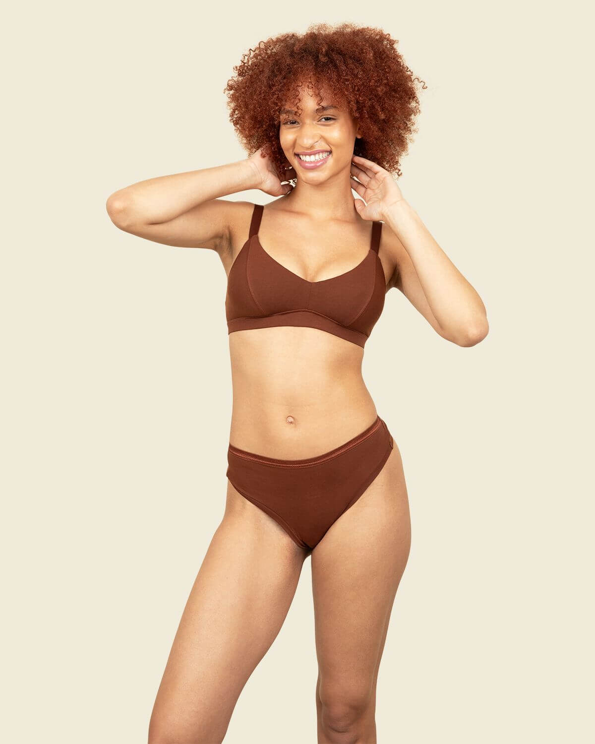 Woman in organic cotton mid-rise thong and triangle soft bra in cacao brown color.