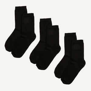 Three pairs of black organic cotton crew socks, designed to sit a few inches above the ankle.