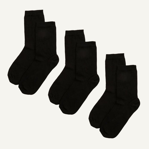 Three pairs of black organic cotton crew socks, designed to sit a few inches above the ankle.