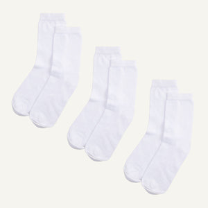 Three pairs of white organic cotton crew socks.
