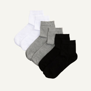 Three pairs of quarter socks in black, gray, and white colors, made of organic cotton, displayed together.