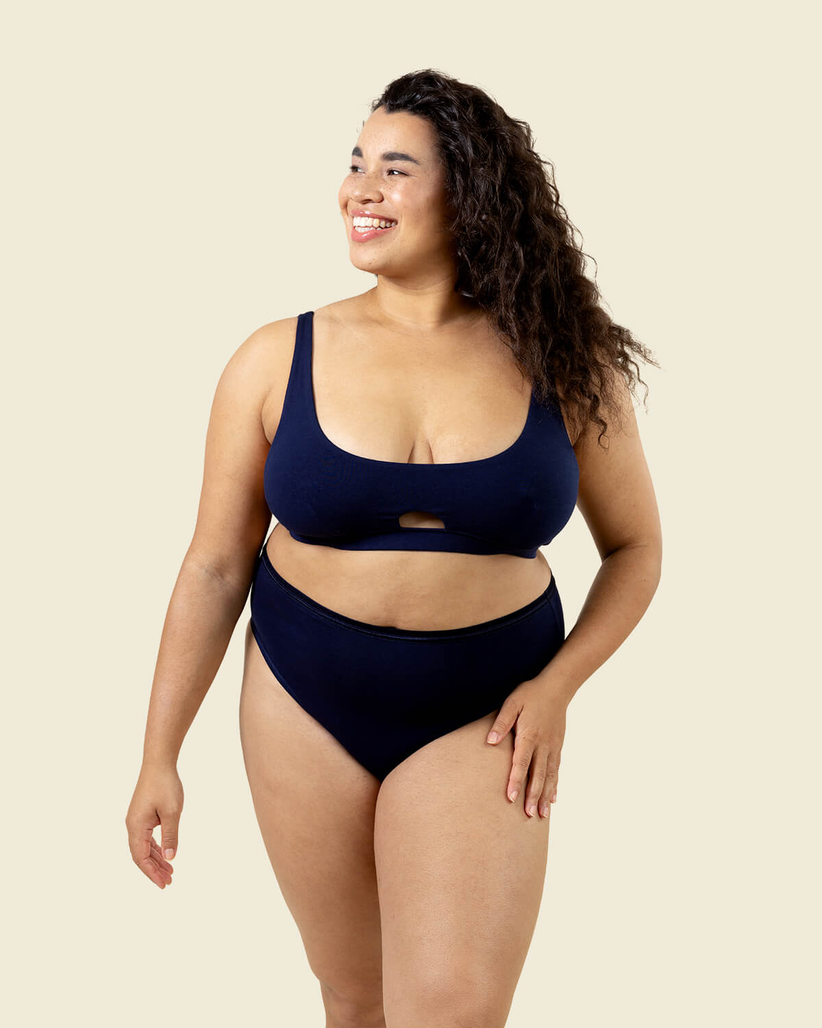 Woman wearing organic cotton high rise brief underwear and keyhole soft bra in marine navy blue color.