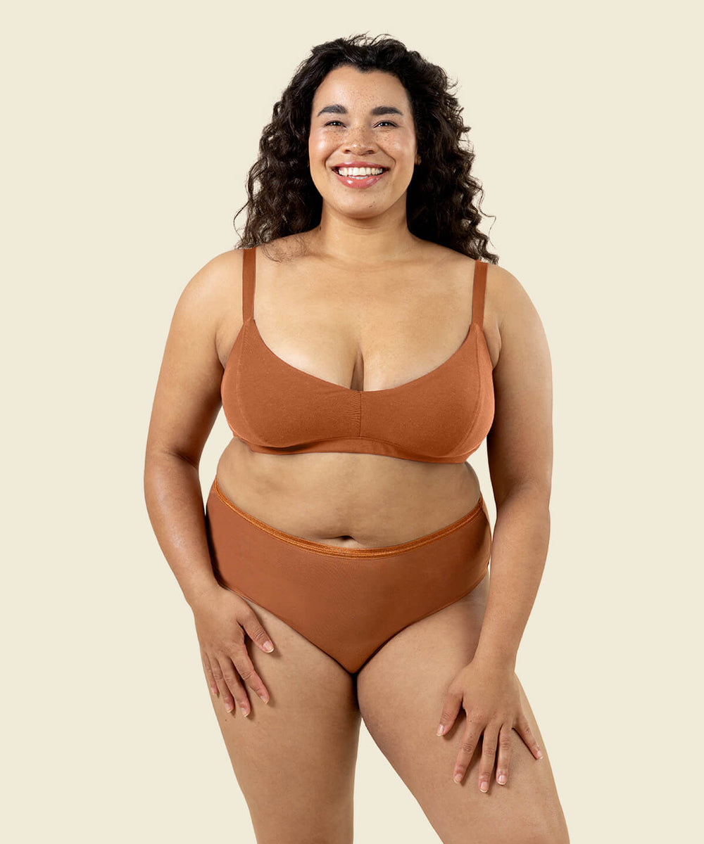 Woman wearing organic cotton high rise brief underwear and triangle soft bra in spice color.