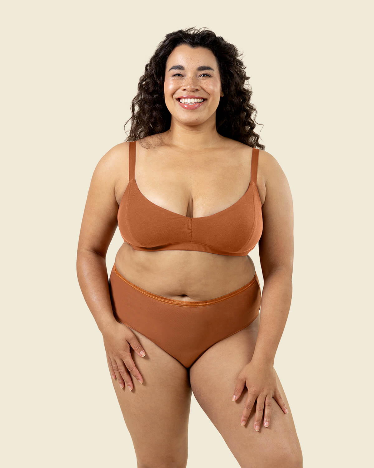 Woman wearing organic cotton high rise brief underwear and triangle soft bra in spice color.