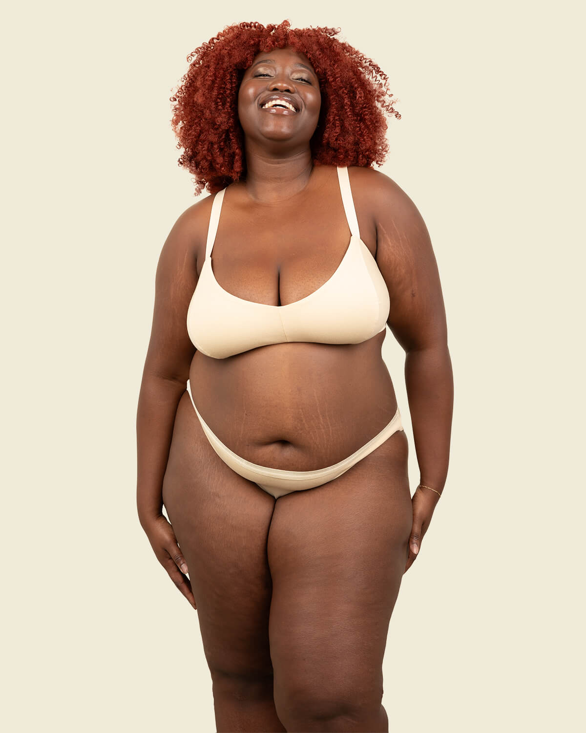 Woman in organic cotton low rise bikini underwear and triangle soft bra in wheat beige color.