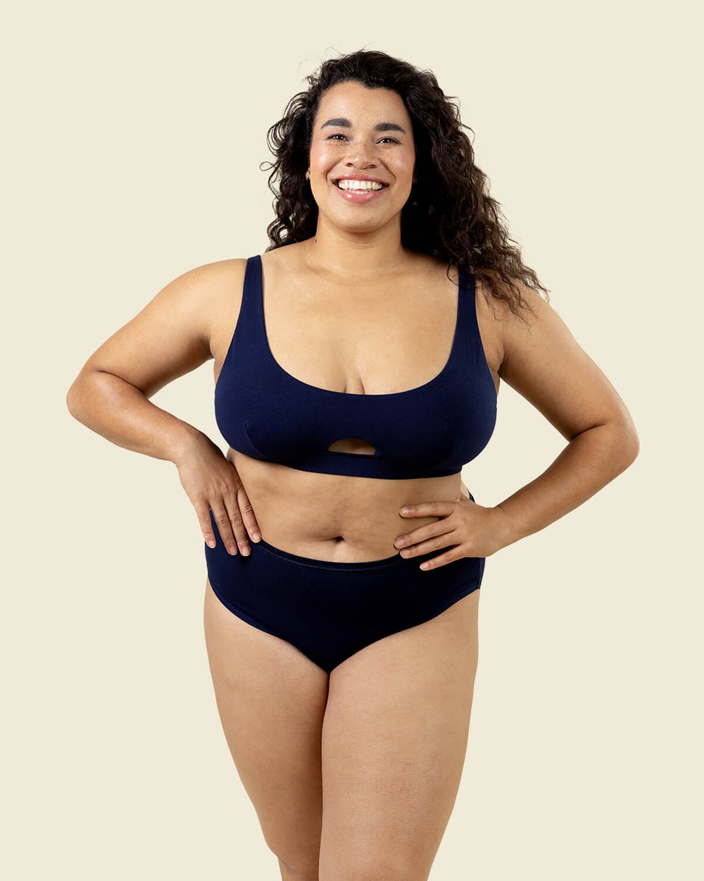 Woman wearing organic cotton mid rise brief underwear and keyhole soft bra in marine navy blue color.